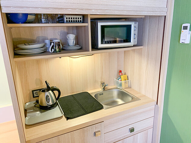 Kitchinette mit Waschbecken, Microwelle und Wasserkocher