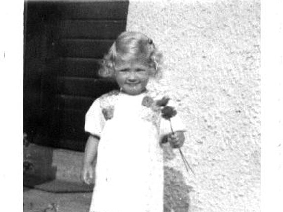 Margit Fichtner mit Blume als kleines Kind