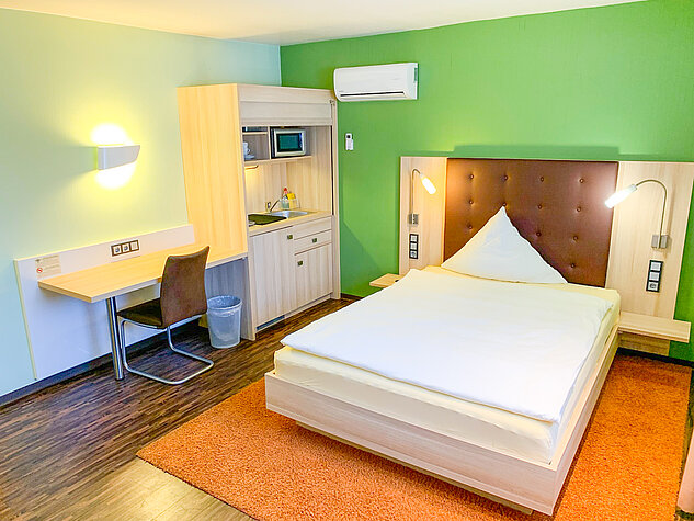 Breites Bett neben der Kitchinette im Zimmer 500 