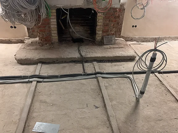 Alter Kamin und Rohbauboden mit Kälteleitungen vor Einbringung des Estrichs