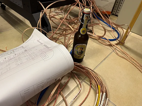 Kabel, Plan und eine Flasche Radler im Serverraum am Boden